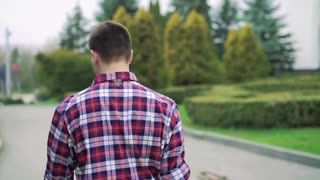 young-man-walking-on-the-street-park-looking-camera-follow-behind-slowly_bklrrgsr__S0000.jpg